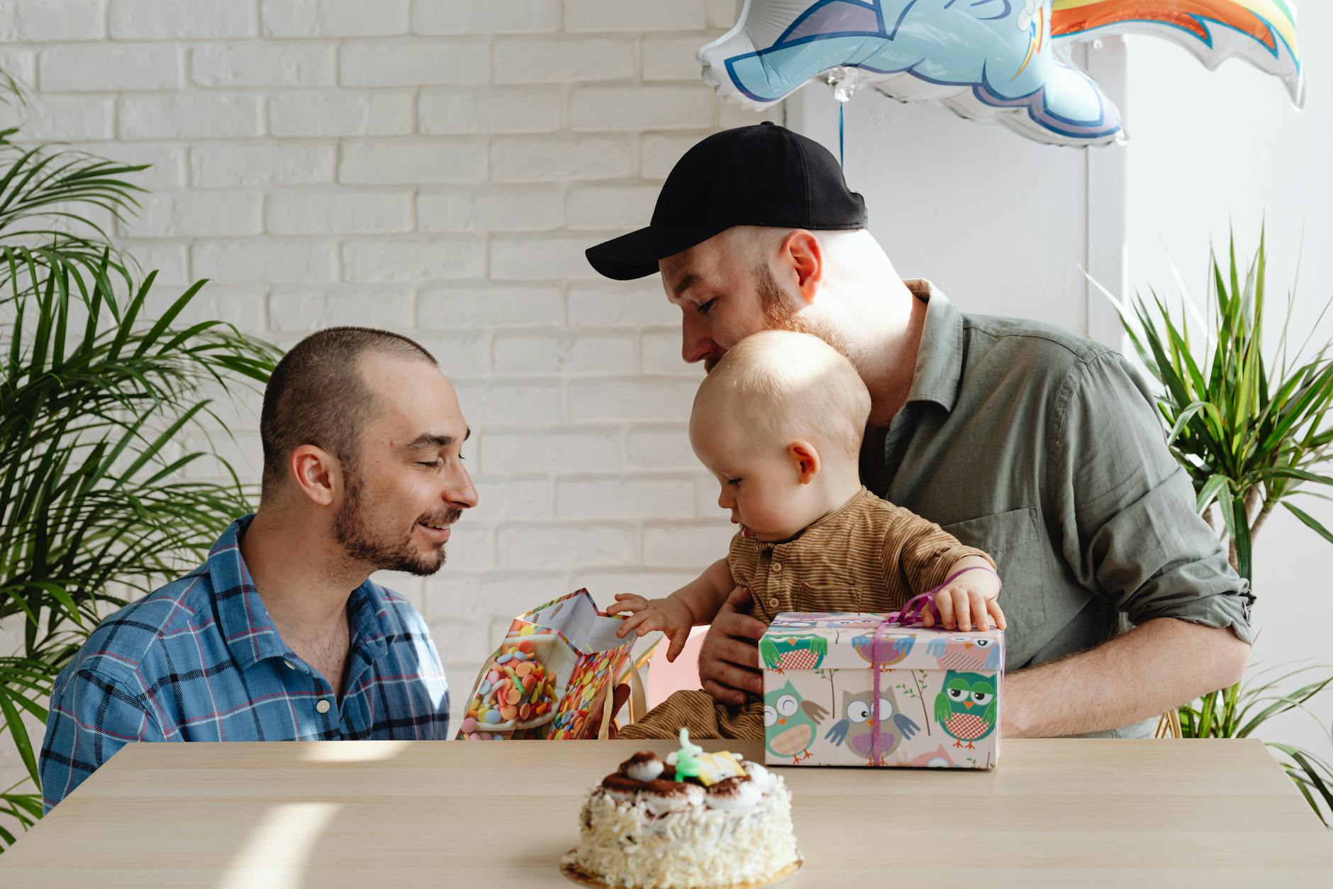 Rodzina w mieszkaniu świętuje z niemowlęciem wśród prezentów Rodzina w mieszkaniu świętuje z niemowlęciem wśród prezentów