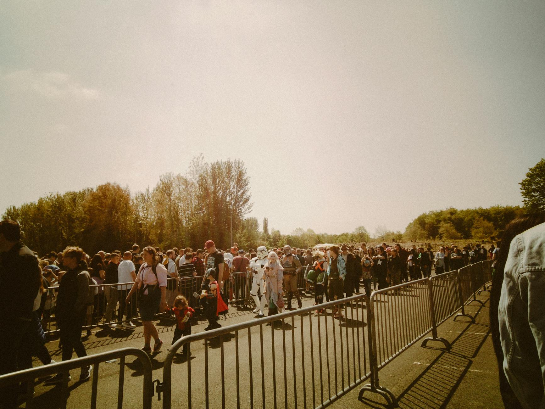 Tłum przebierańców stojących w kolejce na plenerowym festiwalu