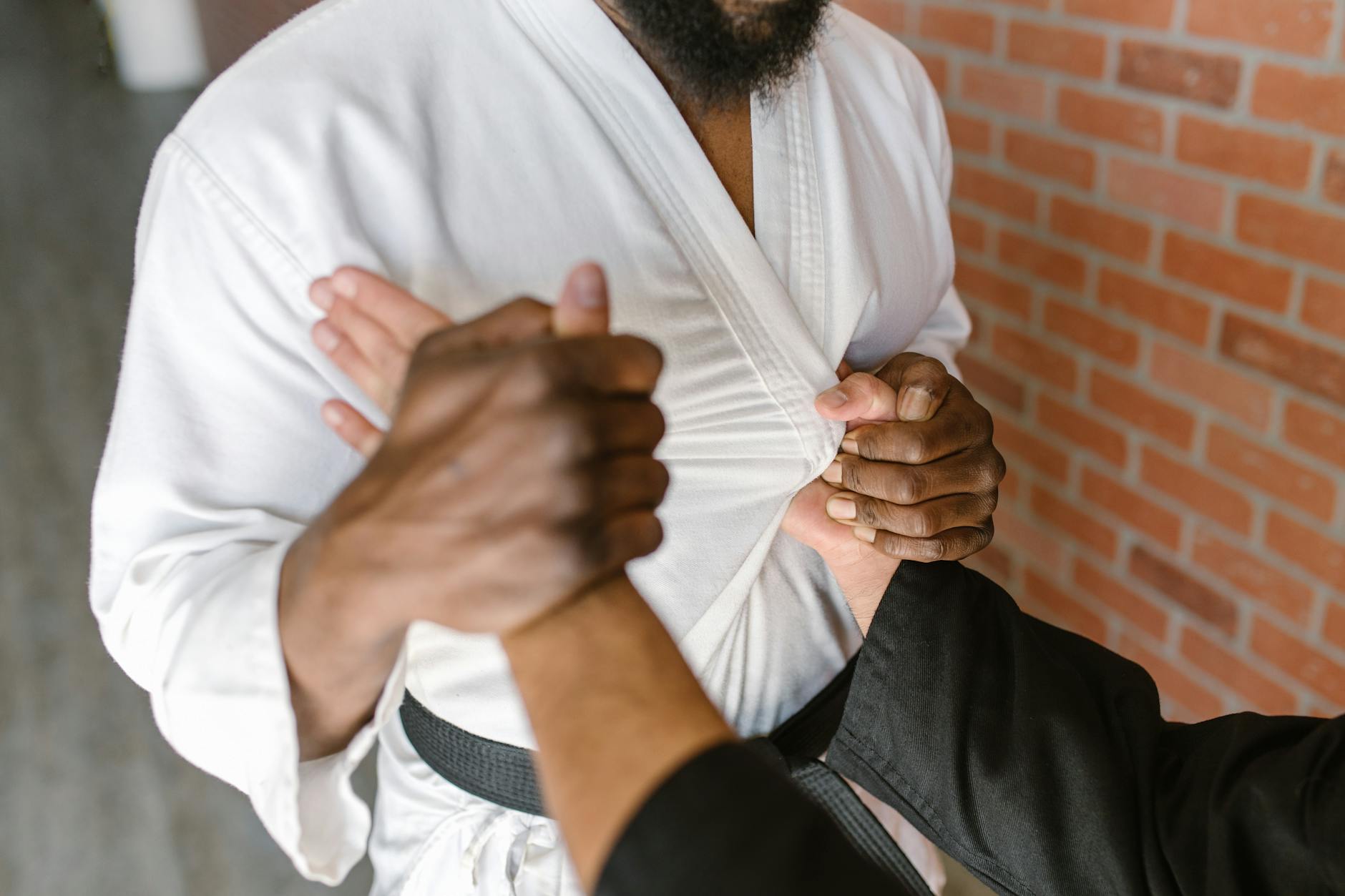 Zbliżenie na dłonie dwóch adeptów Krav Maga trenujących chwyt