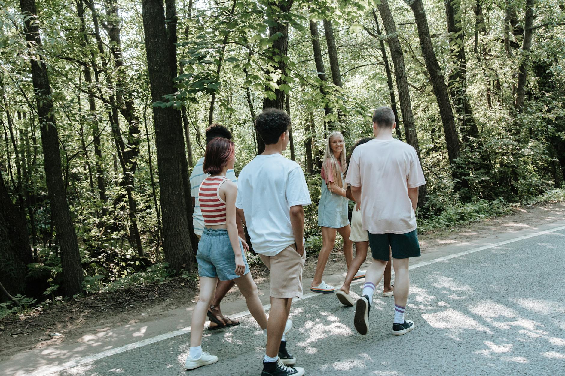 Grupa nastolatków wracająca leśną ścieżką po zajęciach outdoors