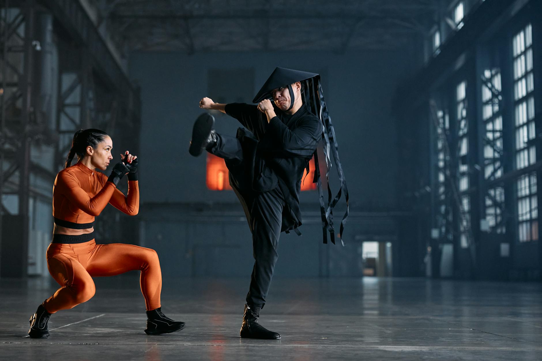 Dwóch cosplayerów w pozach sztuk walki w industrialnym wnętrzu