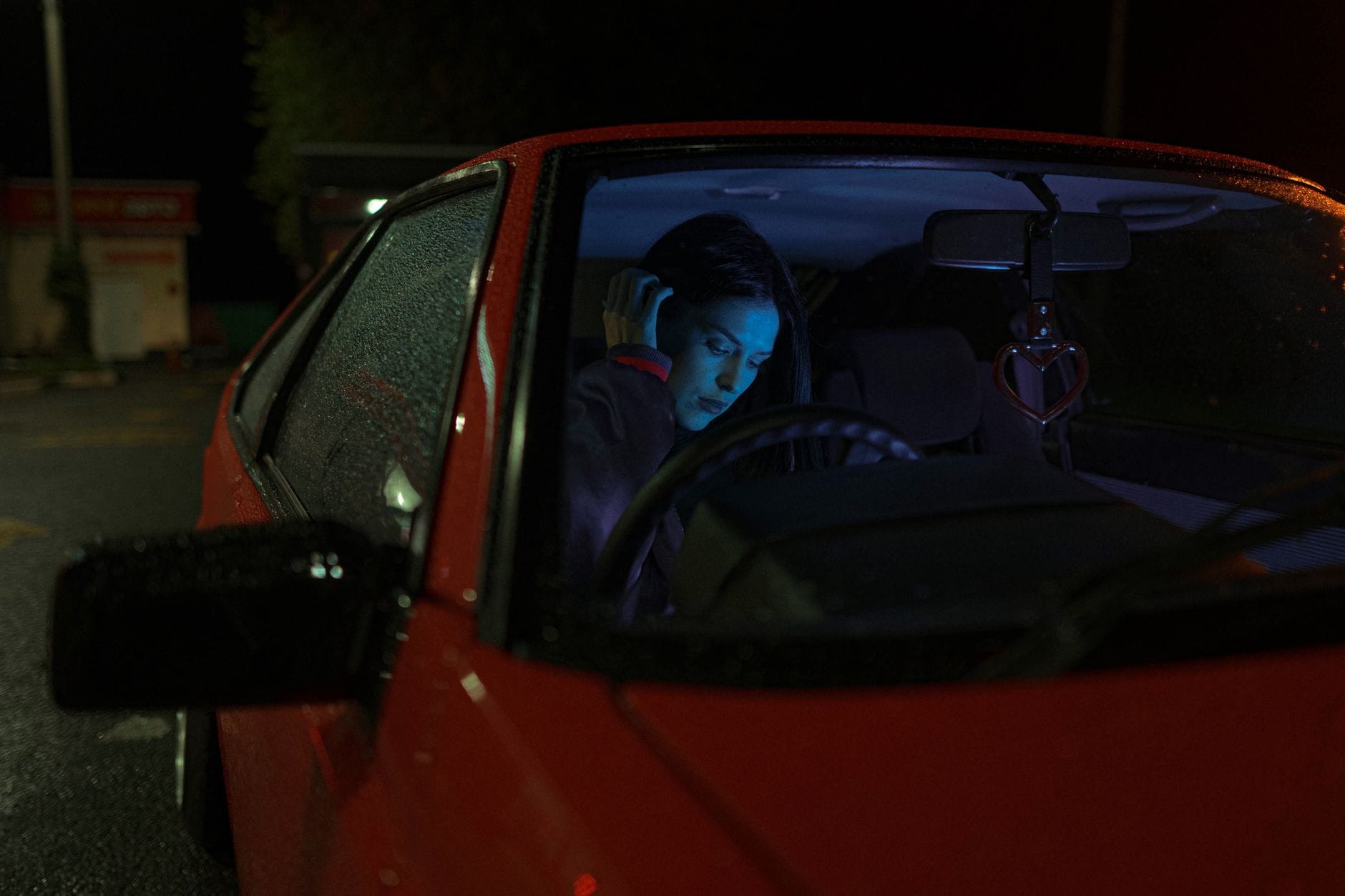 Samochód jako pułapka: jak uniknąć „carjackingu” i co zrobić, gdy ktoś podchodzi do drzwi Kobieta siedzi samotnie w zaparkowanym samochodzie nocą